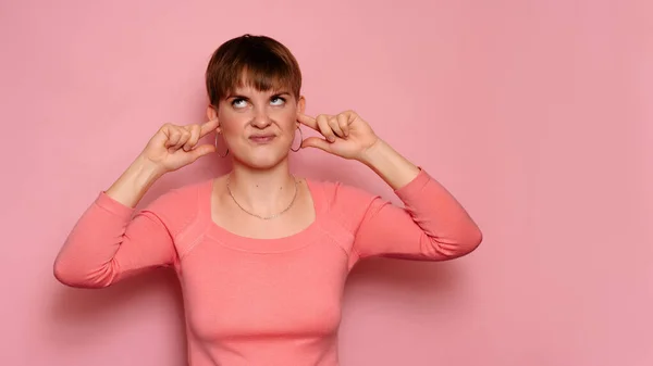 Wściekła Podrażniona Młoda Kobieta Odizolowana Różowym Tle Zakrywa Uszy Głośnych — Zdjęcie stockowe