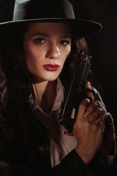 コートと帽子の女性刑事のシルエット銃を手にして 1950年代の探偵風の本のドラマのノワールの肖像画 — ストック写真