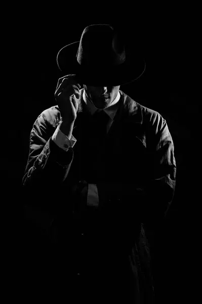 스타일의 코트와 모자에 남자의 어두운 실루엣 1950년대와 60년대의 스타일의 극적인 스톡 사진