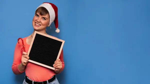 Uma Mulher Sorridente Atraente Chapéu Vermelho Papai Noel Segurando Quadro — Fotografia de Stock