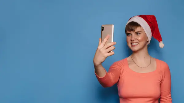 Uma Mulher Sorridente Atraente Chapéu Papai Noel Segura Telefone Suas — Fotografia de Stock