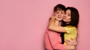 İki genç kızın mutlu ve parlak geçmişli en iyi arkadaşlarıyla çekilmiş bir stüdyo fotoğrafı. Mesajınız ya da ilanınız için bir yer