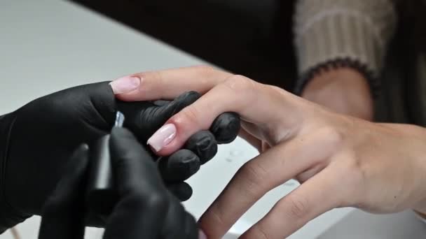 マニキュア サービス マニキュリストは透明ジェルポリッシュで爪をペイントします ネイルポリッシュを施す よく手入れされた爪 マニキュアマスターは 美容室でクライアントの爪をペイント — ストック動画