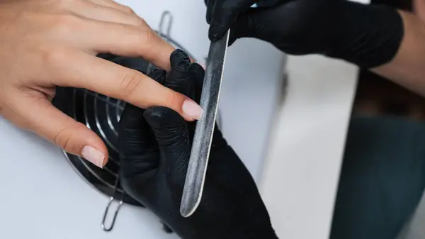 Close-up of a manicure master sawing a nail file. The concept of salon professional manicure.