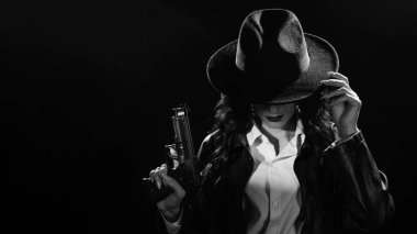 Paltolu ve şapkalı elinde silah olan bir kadın dedektifin silueti. 1950 'lerin dedektiflerinin tarzında bir kara dram portresi. siyah ve beyaz enstantane