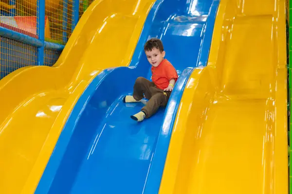 Ein Junge Reitet Von Der Kinderrutsche Auf Den Spielplatz Spielzentrum Stockbild