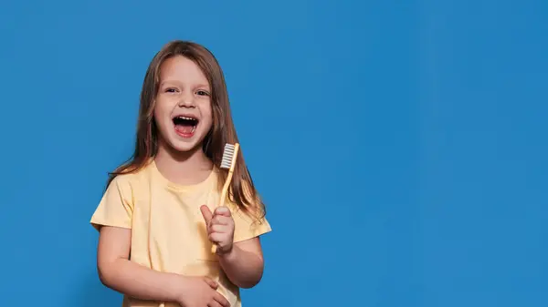 건강한 치아를 소녀는 노란색 배경에 그녀의 칫솔을 당신의 본문을위한 위생이요 로열티 프리 스톡 이미지