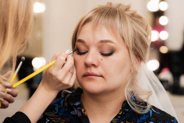 Kadınların elleri makyaj fırçasıyla göz farı sürer ve gölgeler..