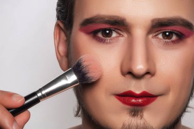 Yakışıklı sakallı adam kendi makyajını yapıyor..