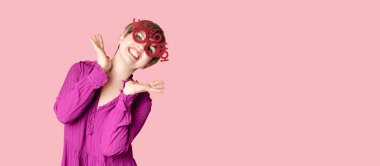 Noel gözlüklü neşeli genç bir kadın pembe arka planda poz veriyor. Mesajın için bir yer. 2025 yılının kutlanması şerefine neşeli bir konsept..