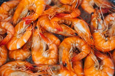 Kızartma tavasında yağda kızartılmış bölünmemiş karidesin yakın çekim görüntüsü.