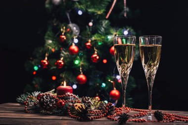 Şampanya kadehleri Noel arkaplanı dekore edilmiş Noel ağacı ve çelenk