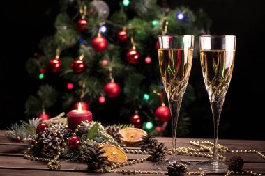Şampanya kadehleri Noel arkaplanı dekore edilmiş Noel ağacı ve çelenk