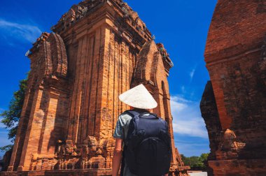 Sırtı Ponagar Kulesi 'nin arka planında duran Vietnamlı bir turist. Thap Ba Po Nagar, Hindistan 'ın Nha Trang şehrinin yakınlarında bulunan bir dinî yerdir..