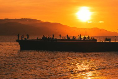 Fishermen at dawn at the pier in Nha Trang, Vietnam. clipart