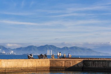 fishermen on the pier in the morning fishing in Nha Trang, Vietnam clipart