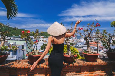 Geleneksel Asya şapkalı genç bir bayan Asya manzarasına bakıyor. Asya 'da seyahat kavramı.