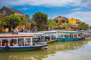 Nehir kenarında dizilmiş fenerlerle süslenmiş renkli geleneksel Vietnam tekneleri Hoi An 'daki fener festivalini kutluyorlar. Vietnam, Hoi An - 1 Aralık 2024.