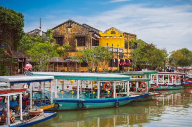 Nehir kenarında dizilmiş fenerlerle süslenmiş renkli geleneksel Vietnam tekneleri Hoi An 'daki fener festivalini kutluyorlar. Vietnam, Hoi An - 1 Aralık 2024.