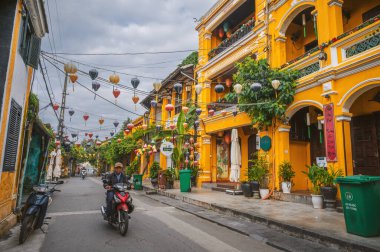 Hoi An 'daki eski bir kasabada, yaz günü geleneksel sarı evleri ve binaları olan bir cadde. Vietnam, Hoi An - 1 Aralık 2024.