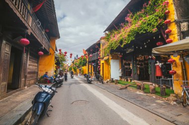 Eski Hoi An şehrinin geleneksel sarı evleri. Vietnam 'ın tarihi Hoi An şehrindeki yerel dükkanlar ve restoranlar. Etkinliğin fotoğrafları. Vietnam, Hoi An - 1 Aralık 2024
