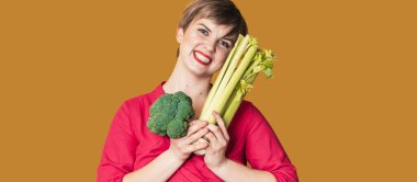 Elinde yeşil sebzelerle gülümseyen ince beyaz kız brokoli ve kereviz, boş alan. Organik sebzeler.