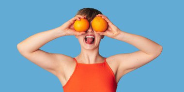 Elinde turunçgil portakallarıyla gülümseyen beyaz bir kız. Panoramik pankart, boş yer. C vitamini