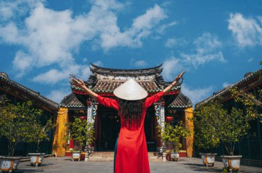 Arka planda geleneksel Vietnamlı bir kadın Fukien Çin Cemaati Toplantı Salonu ve Tapınağı.