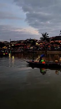 Önde yüzen Vietnam şehri Hoi An 'ın fenerleri ve Tu Bon nehri boyunca fenerli tekneler. Hoi An, Vietnam - 1 Aralık 2024