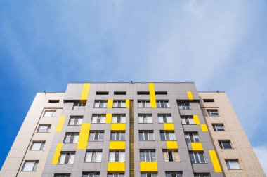 Gökyüzüne karşı çok katlı, modern, yeni ve şık bir konut kompleksinin alçak açılı çekimi.