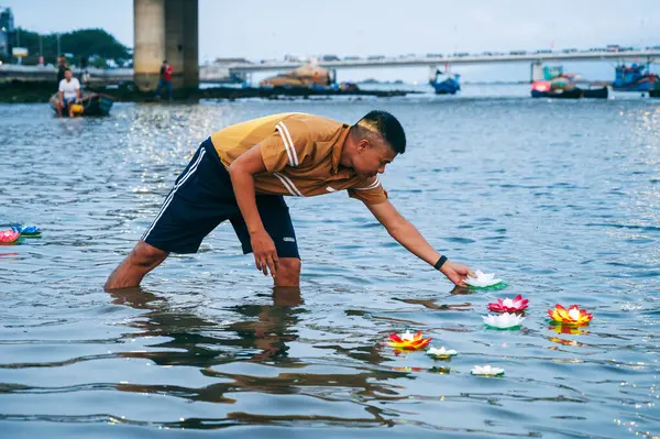 Budist festivalinde yüzen nilüfer şeklinde bir feneri suya fırlatmak..