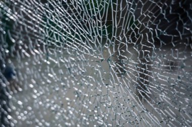 Kırık camların soyut arkaplanı çok sayıda parça ve parçaya ayrılır. Bir sürü çatlak ve kırık parçaları olan bir cam parçası.