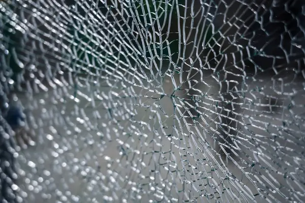 Kırık camların soyut arkaplanı çok sayıda parça ve parçaya ayrılır. Bir sürü çatlak ve kırık parçaları olan bir cam parçası.