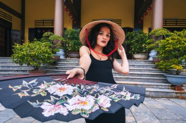 Vietnam Non La şapkalı bir turist ve arka planda Da Nang 'daki Linh Ung pagoda' nın güzel manzaralarının resmedilmiş bir hayranı.
