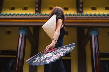 Da Nang 'daki Linh Ung Son Tra pagoda' nın arka planında geleneksel Vietnamlı Non La şapkalı bir turist kadın.
