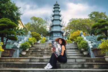 Vietnam 'da Da Nang, Vietnam' daki Linh Un pagoda 'daki Budist tapınağının arka planında bir kadın turist..
