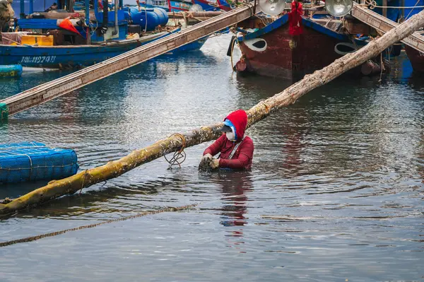 Denizde midye ve istiridye çiftliğinde yaşayan geleneksel bir balıkçı ya da midye çiftçisi. Da Nang, Vietnam - 30 Kasım 2024
