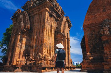 Sırtı Ponagar Kulesi 'nin arka planında duran Vietnamlı bir turist. Thap Ba Po Nagar, Hindistan 'ın Nha Trang şehrinin yakınlarında bulunan bir dinî yerdir..