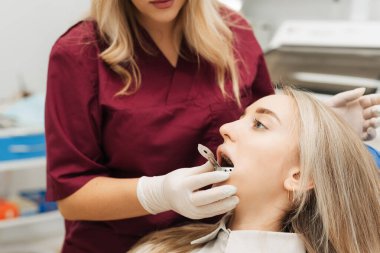 Diş hekimi hastaya diş teli takmak için diş izi bırakır. Yakın plan. Gerçek insanlar.