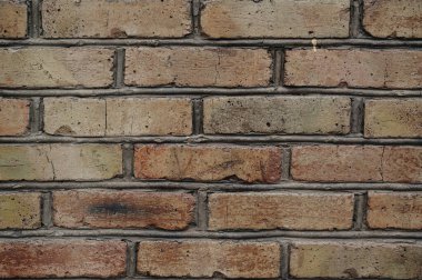 Kırmızılı ve kahverengi tuğlalı eski, yıpranmış tuğla duvar tamir edilmesi gerekiyor..