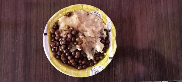 Sweet Halwa and  Black chickpeas mixture in tray on wooden table