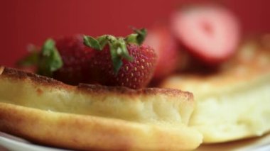 Masada dönen çilekli Belçika waffleları. Lezzetli bir kahvaltı konsepti.