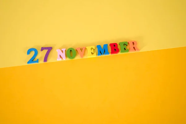 11月27日黄色と紙の背景にテキストのためのスペースを持つ木製と多色の文字で その日のコンセプトはブラック フライデー — ストック写真