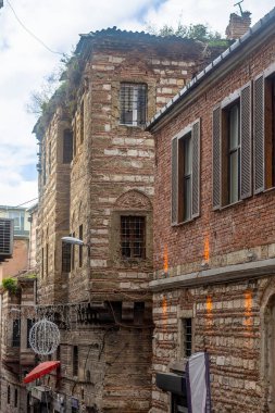 Binanın sarı kaplamalı küçük balkonlu eski bir bina, İstanbul şehrinde kablolar var. Turizm ve seyahat kavramı.