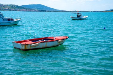 Yazın ve güneşli bir günde bir Türk kasabasının arka planında eski ve küçük bir balıkçı teknesi. Turizm ve seyahat kavramı.
