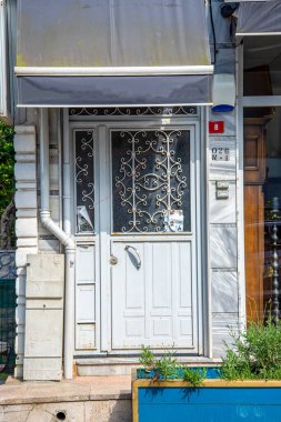Beyaz metal, beyaz yüzlü bir yerleşim bölgesinde demir kapı dövmesi yapılmış. Tasarım ve inşaat konsepti.