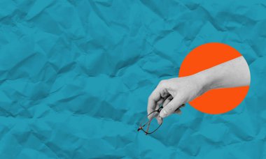 Kompozit kolaj, mavi ve turuncu dairelerin kağıdında gözlüklü bir elin sanat kolajı resmi. Reklam veya metin için boşluk.