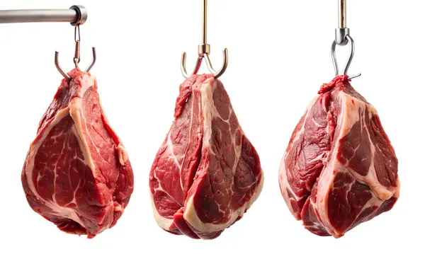 Beyaz arka planda metal kancada çiğ et parçaları var. Taze et kavramı.