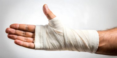 Yaralı el, bandajlı kırık bilek. Kırık bir kol ve yaralanma için tedavi kavramları.