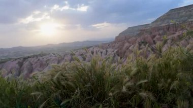 Güneş ufukta batarken Cappadocia 'daki renkli kaya oluşumlarının büyüleyici görüntüsünü deneyimleyin. Bu doğal manzara bölgenin olağanüstü jeolojik özelliklerini vurguluyor..